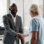 African American lawyer in suit smiling and greeting client in office